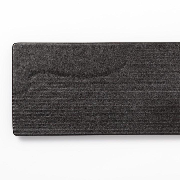 Rectangular black ceramic serving plate with a subtle ridged woodgrain texture, perfect for stylish Japanese meals and contemporary plating.