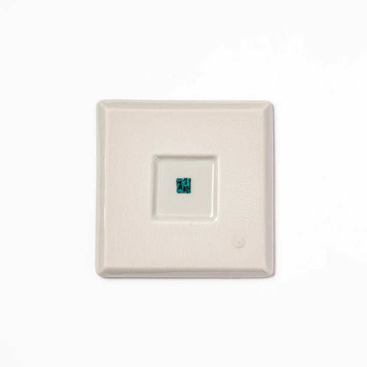 Square Japanese ceramic coaster adorned with vivid yellow peony blooms and teal leaves, adding elegance and charm to any dining table setting.
