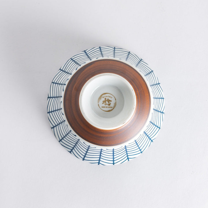 Ceramic ramen bowl with blue striped pattern on white background.
