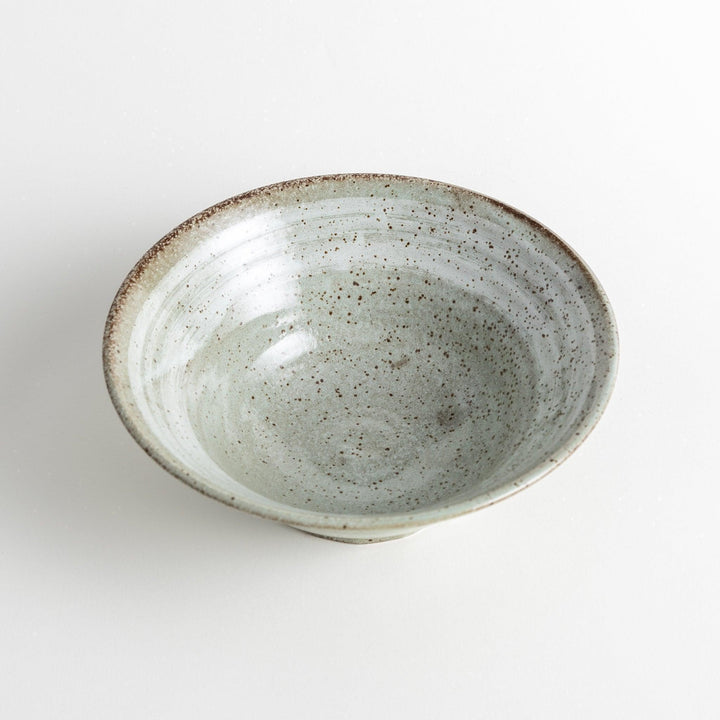 A light gray, wide-rimmed bowl with a textured and speckled surface.