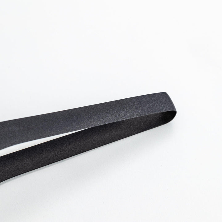 Sleek, matte black serving tongs with smooth curves, ideal for precise handling of small foods.