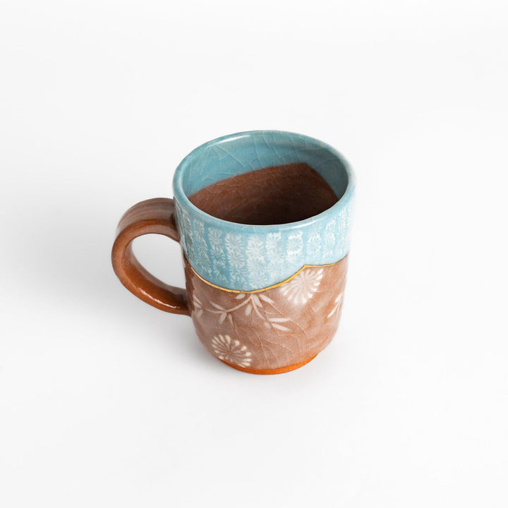 Azure floral elegance mug with delicate flower patterns and gold detailing on the rim, perfect for enjoying hot beverages in style.