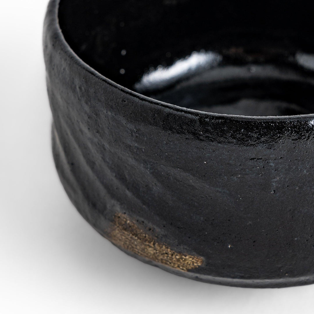 Unique black Raku ware Matcha bowl, handcrafted with traditional Japanese techniques, featuring a rustic texture and a wabi-sabi aesthetic.