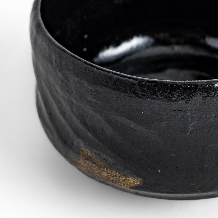 Unique black Raku ware Matcha bowl, handcrafted with traditional Japanese techniques, featuring a rustic texture and a wabi-sabi aesthetic.