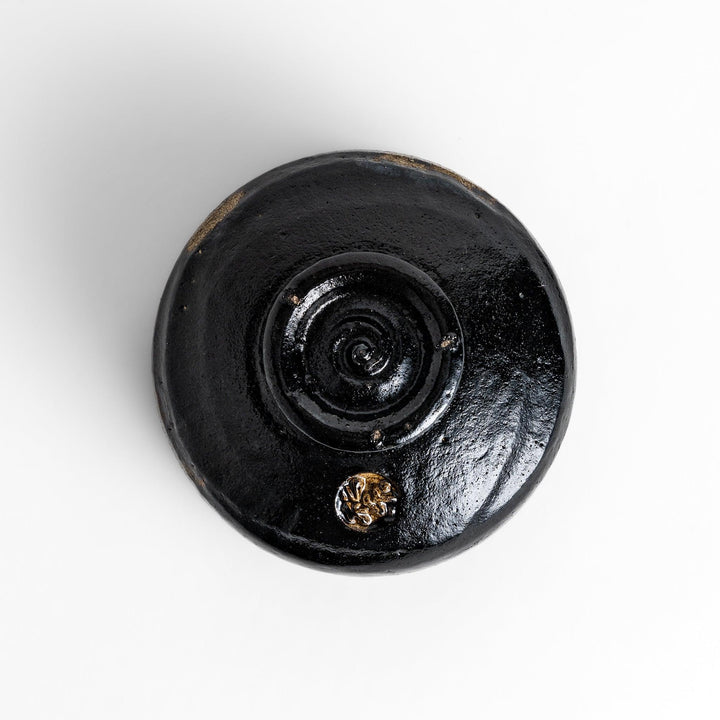 Unique black Raku ware Matcha bowl, handcrafted with traditional Japanese techniques, featuring a rustic texture and a wabi-sabi aesthetic.