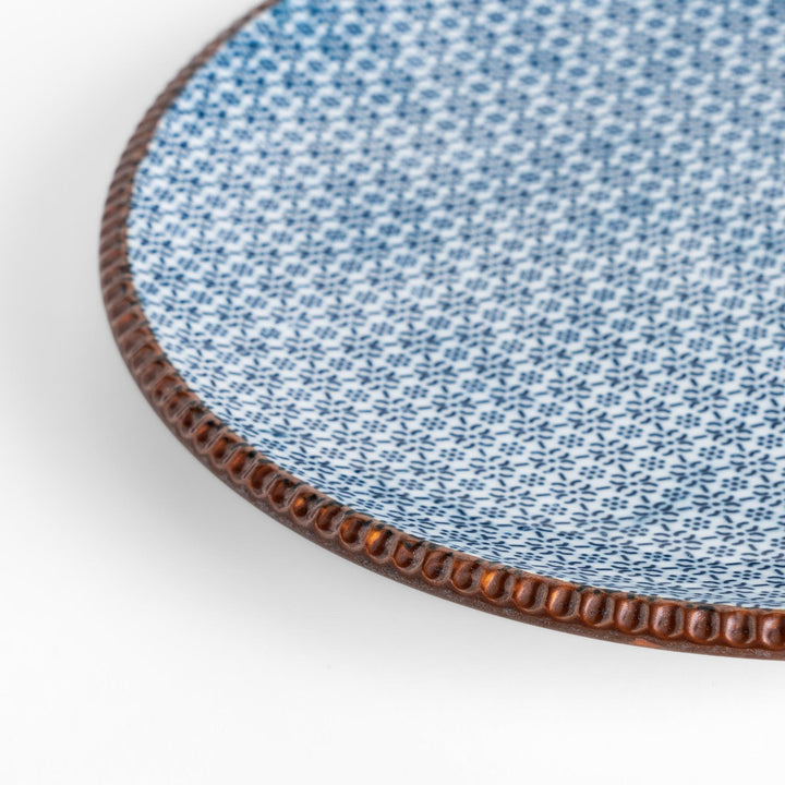 Blue and white patterned Dinner Plate featuring a delicate floral design and a brown textured rim, perfect for elegant dining settings.