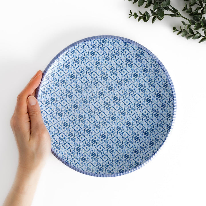 Blue and white floral patterned Dinner Plate with a subtle striped rim, offering an elegant touch for refined dining presentations.