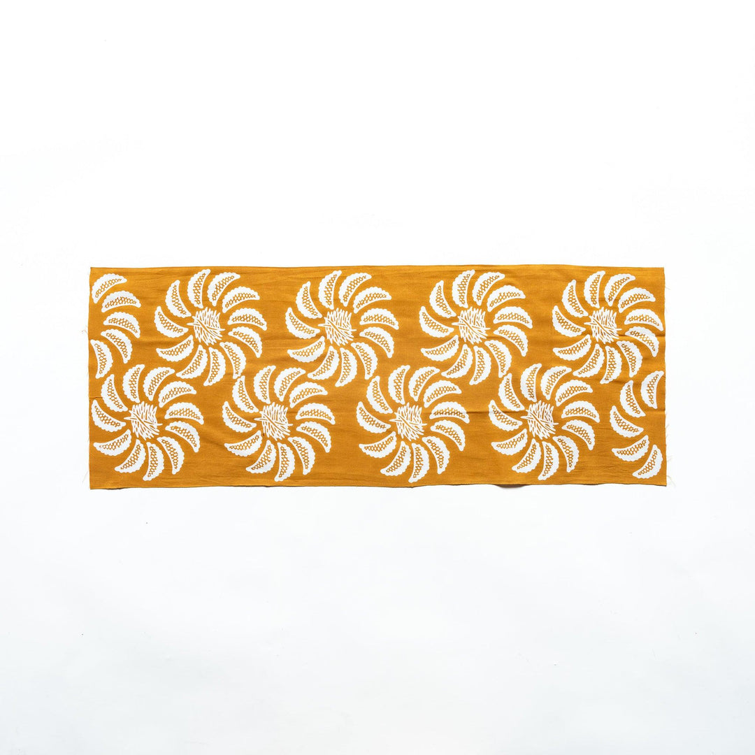 Mustard yellow tenugui laid flat, displaying the floral gyoza pattern.