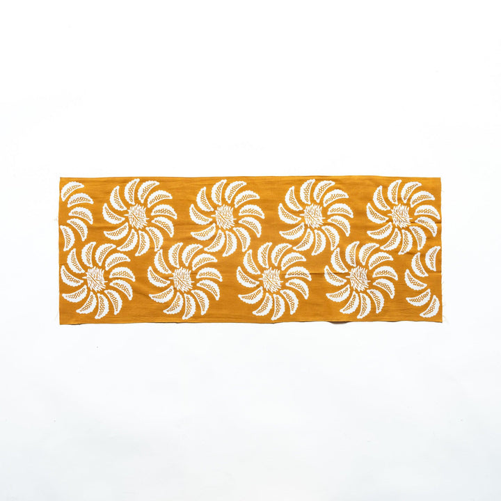 Mustard yellow tenugui laid flat, displaying the floral gyoza pattern.