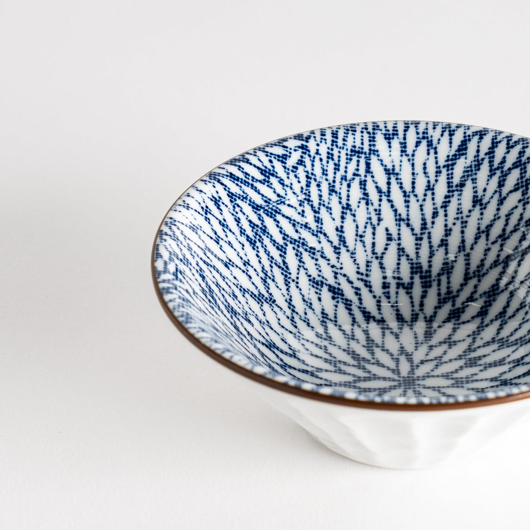 A small fluted bowl with a blue herringbone pattern on a white background.
