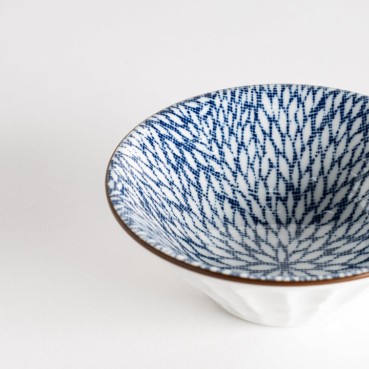 A small fluted bowl with a blue herringbone pattern on a white background.