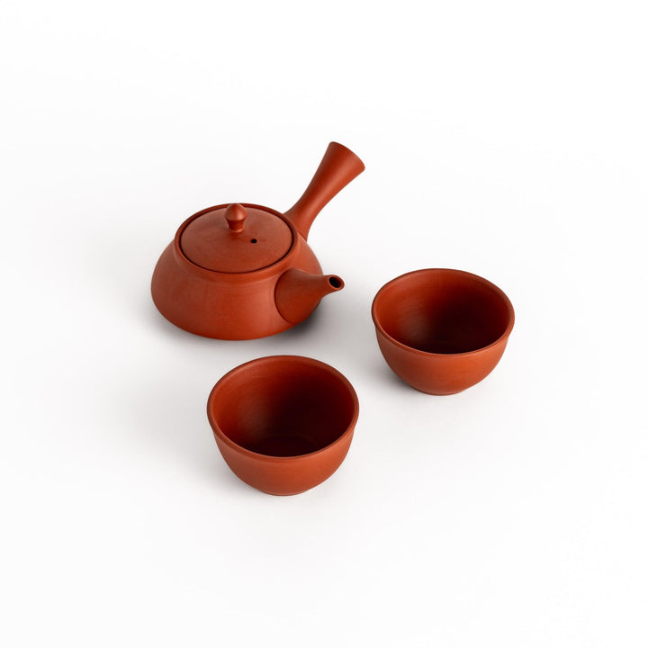 Elegant crimson tea set featuring a round teapot with spout and matching bowls, perfect for enjoying tea with simplicity and style.