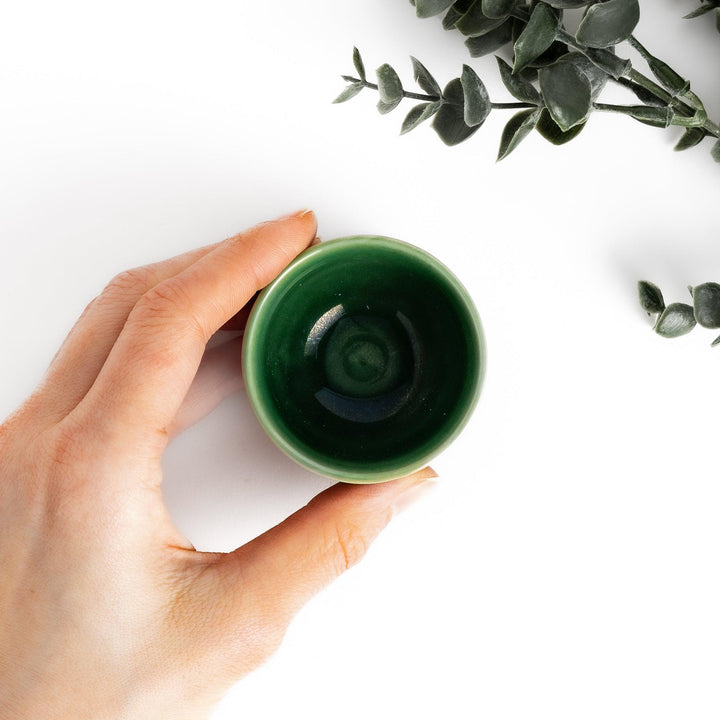 Deep green ceramic sake cup with a glossy textured finish and rounded shape, ideal for enjoying traditional Japanese sake rituals.