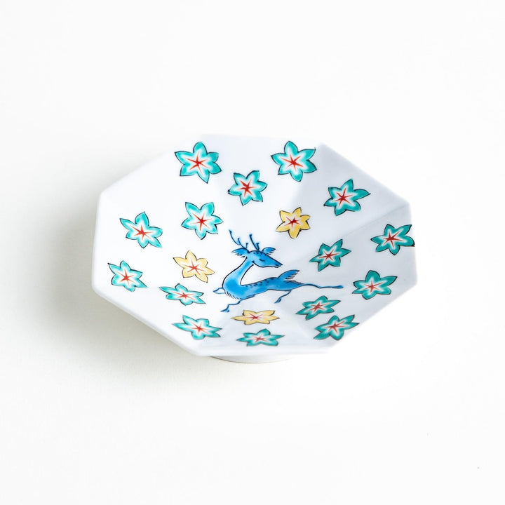 Octagonal plate with a blue deer surrounded by red and green floral patterns.