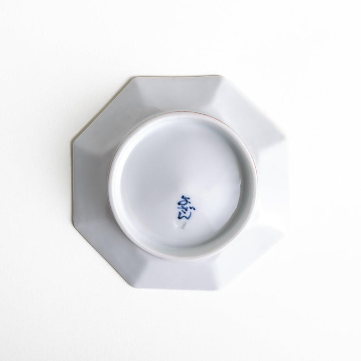 Octagonal plate with a blue deer surrounded by red and green floral patterns.