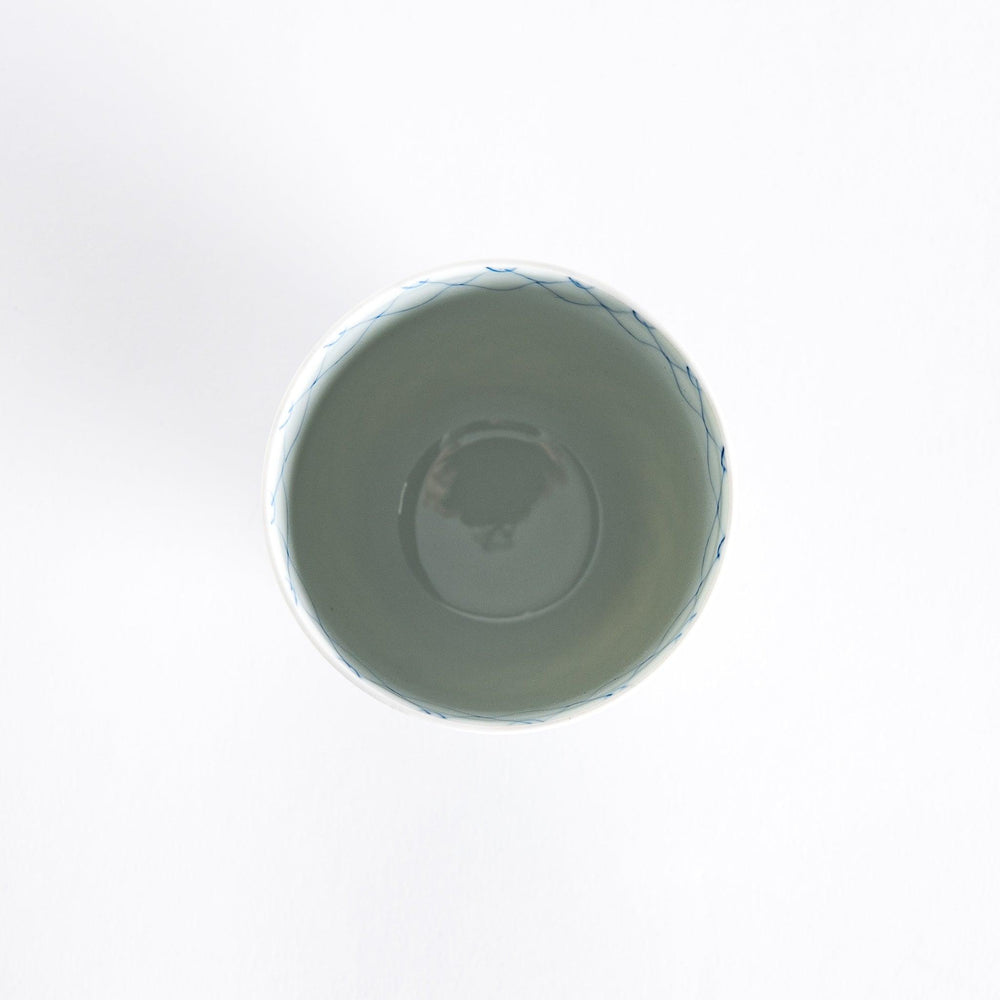 Top-down view of the tea cup held in hand, showing its smooth rim and interior.