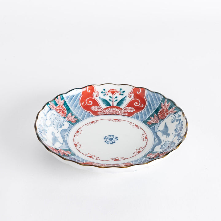 Side view of the decorative plate, highlighting its scalloped edges and colorful floral patterns.