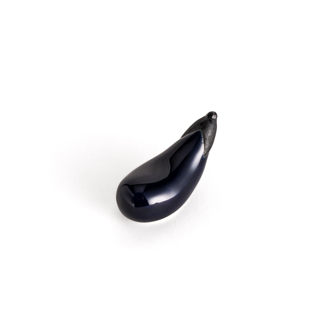 Glossy ceramic eggplant chopstick rest in deep purple with a textured black stem, perfect for adding a unique touch to your dining setting.