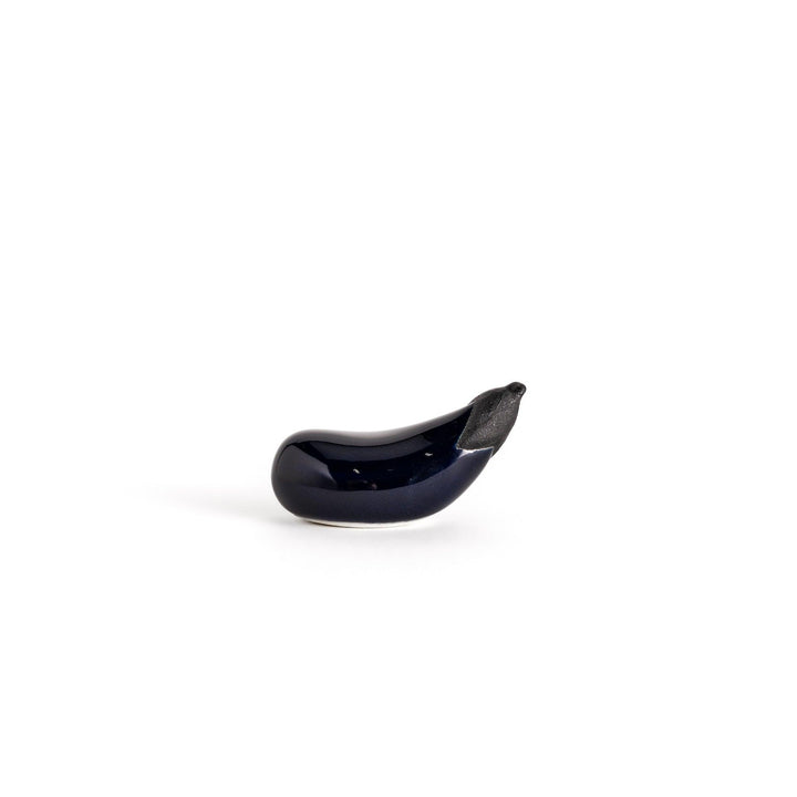Glossy ceramic eggplant chopstick rest in deep purple with a textured black stem, perfect for adding a unique touch to your dining setting.