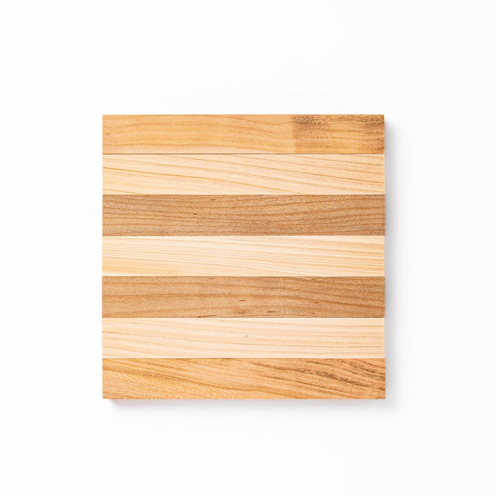 Expandable hinoki and cherry wood trivet with slats fanned out, showing mixed wood tones for versatile pot support