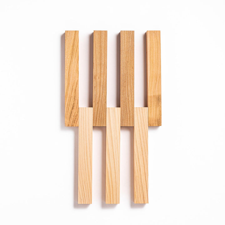 Expandable hinoki and cherry wood trivet with slats fanned out, showing mixed wood tones for versatile pot support