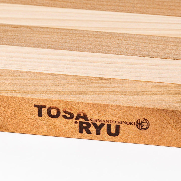 Expandable hinoki and cherry wood trivet with slats fanned out, showing mixed wood tones for versatile pot support