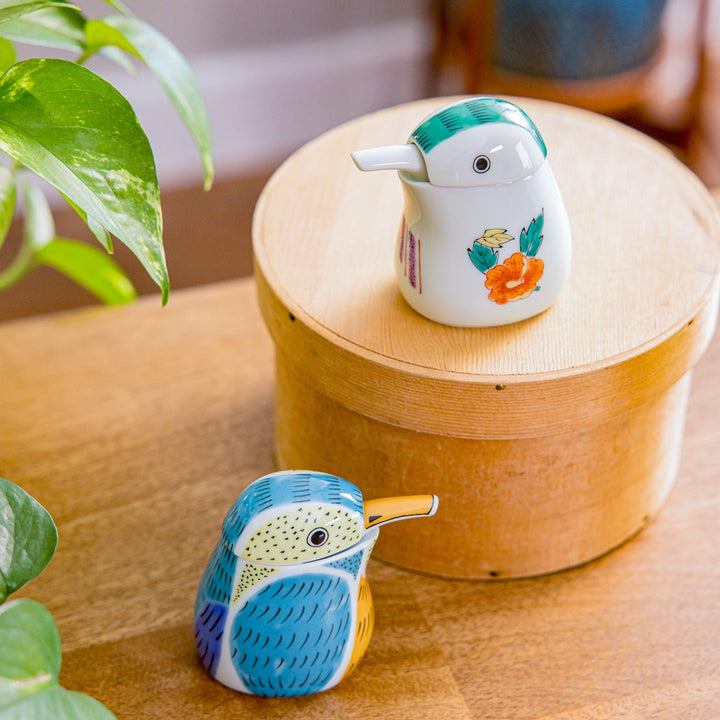 A charming white soy sauce dispenser shaped like a bird, adorned with colorful floral designs. Perfect for adding a playful touch to your dining table.