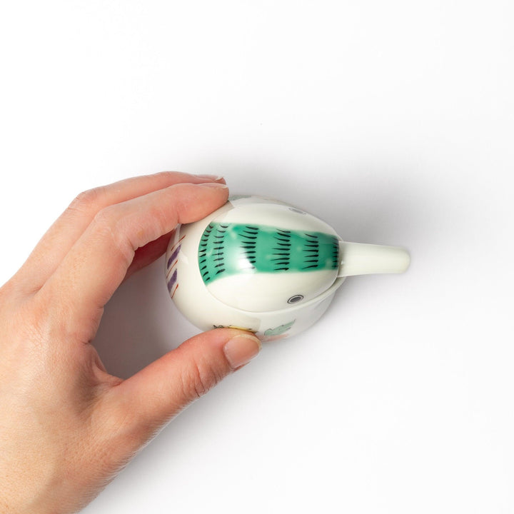 A bird-shaped soy sauce dispenser featuring a traditional floral design in red, green, and orange.