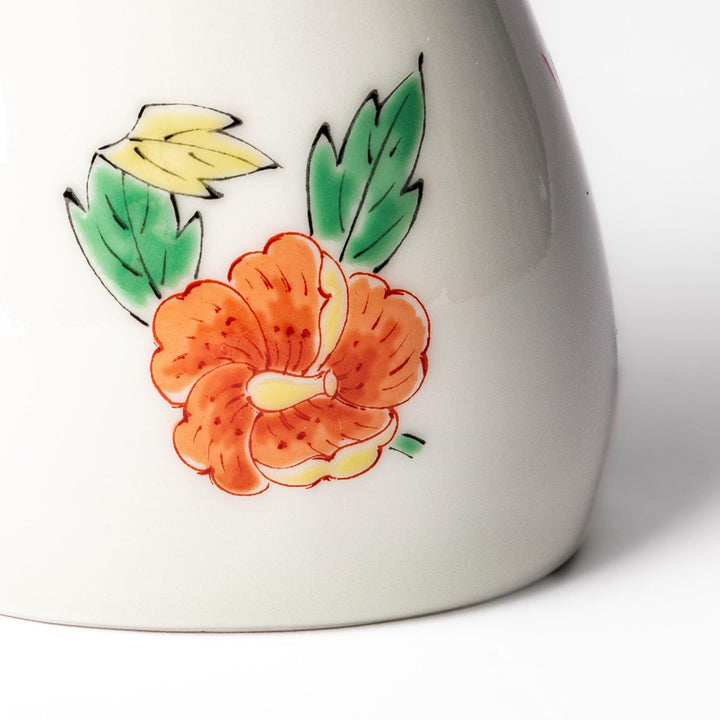 A bird-shaped soy sauce dispenser featuring a traditional floral design in red, green, and orange.