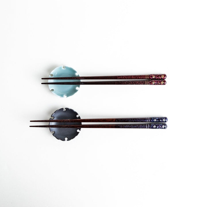 A pair of chopsticks with a sleek design featuring glitter accents and small floral patterns in deep red and navy blue, adding a touch of sparkle to your dining experience.