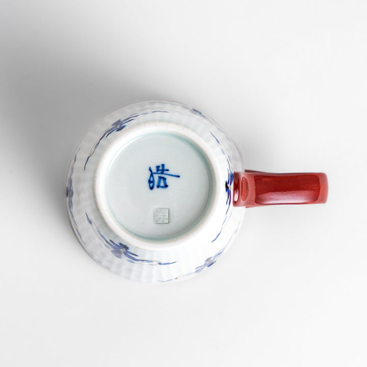 Charming floral leaves mug with intricate blue floral patterns, complemented by a red handle and gold trim, adding a touch of elegance to your tea time.