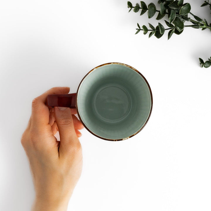 Charming floral leaves mug with intricate blue floral patterns, complemented by a red handle and gold trim, adding a touch of elegance to your tea time.