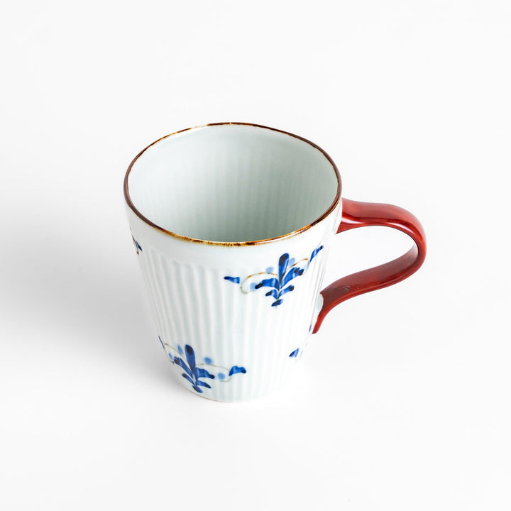 Charming floral leaves mug with intricate blue floral patterns, complemented by a red handle and gold trim, adding a touch of elegance to your tea time.