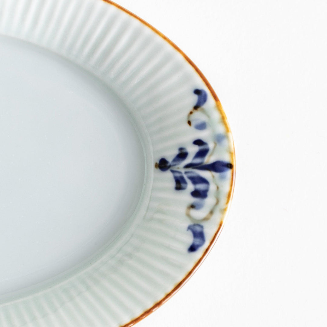 A small oval porcelain plate with subtle blue floral accents on the edges.