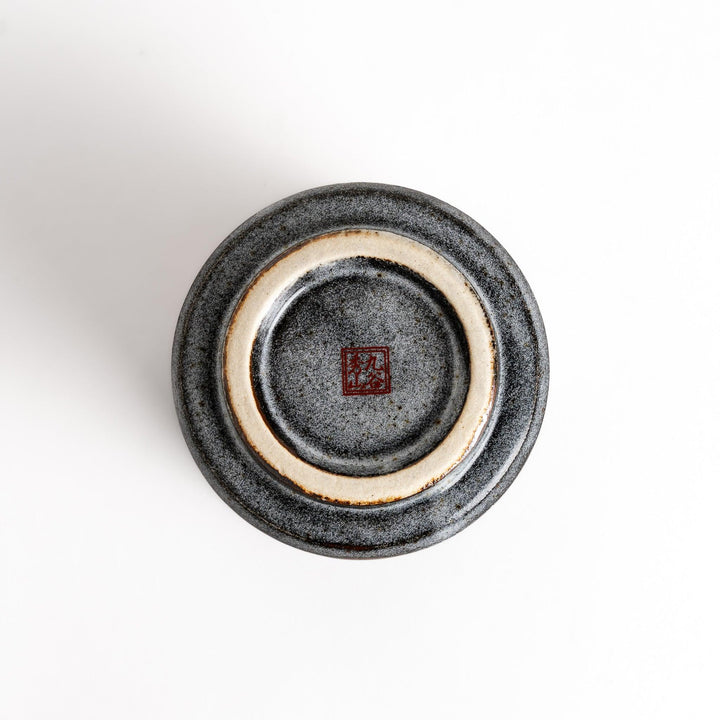 Gray ceramic teacup with a vibrant floral pattern in gold and pastel colors, featuring a unique speckled glaze and a slightly flared rim.