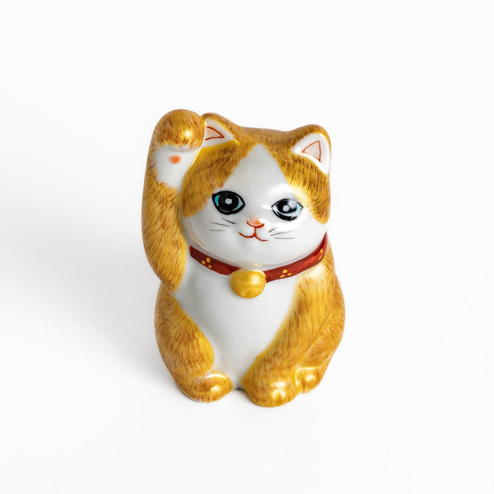 Maneki Neko figurine with a golden brush design, featuring a waving cat with a collar and bell for good luck.