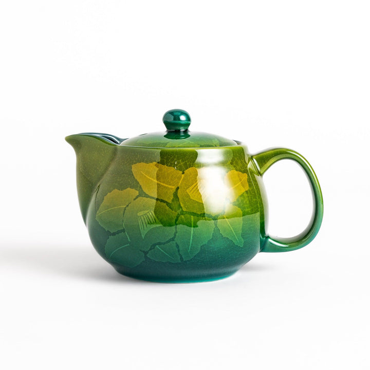 Glossy green ceramic teapot with a subtle leaf pattern, gradient design, and secure lid, perfect for brewing and serving your favorite tea.