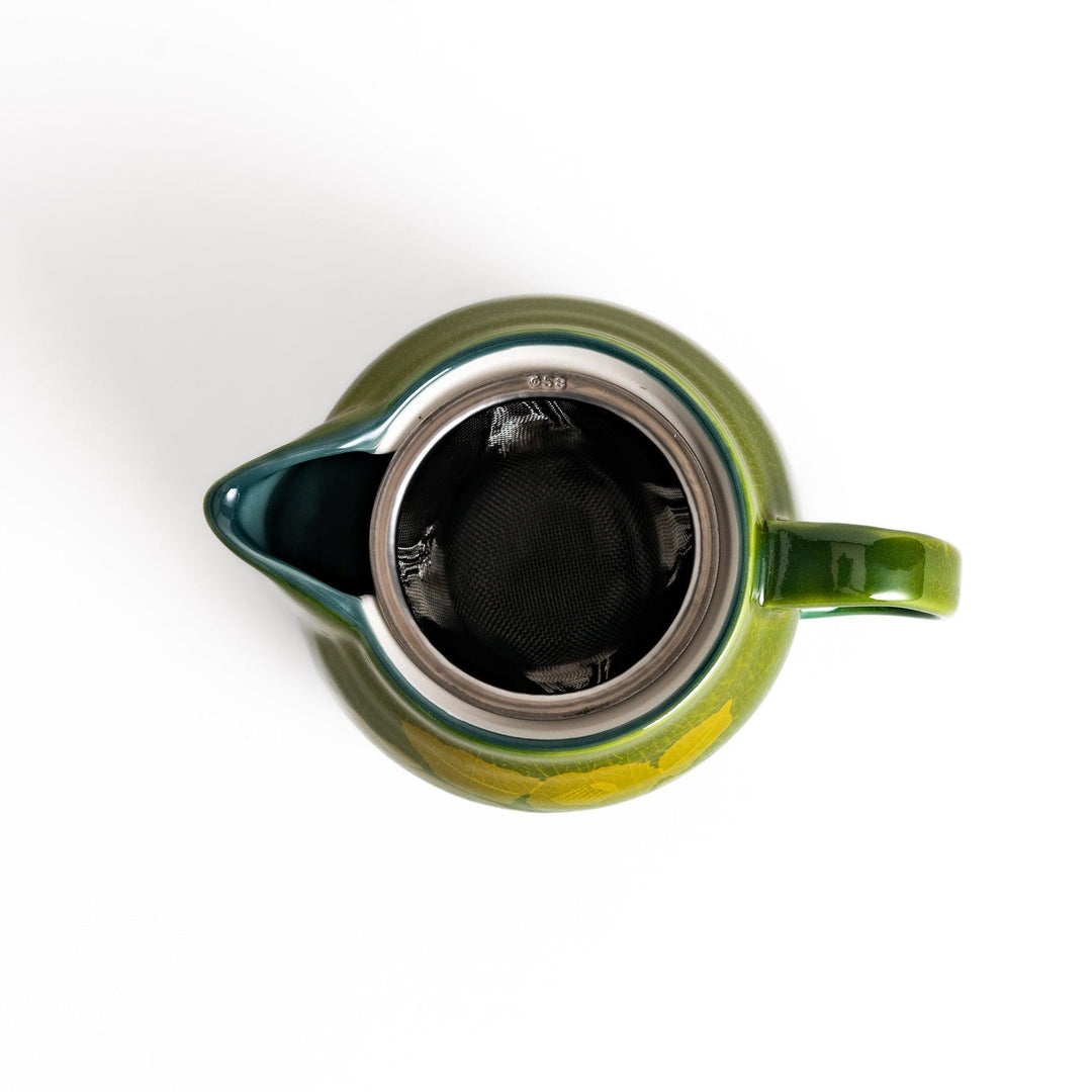 Glossy green ceramic teapot with a subtle leaf pattern, gradient design, and secure lid, perfect for brewing and serving your favorite tea.