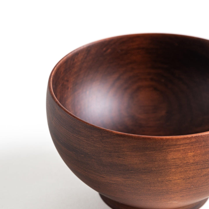 Close-up of the brown wooden bowl showing unique craftsmanship, making it a lovely addition to any kitchen.