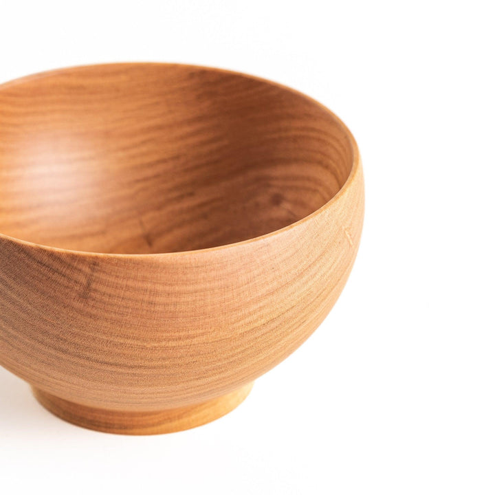 Close-up of the handcrafted wooden bowl, highlighting its rich texture and craftsmanship, ideal for dining occasions.