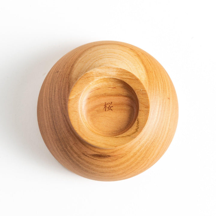 Base view of the wooden bowl revealing intricate craftsmanship and a unique mark, perfect for collectors and chefs.