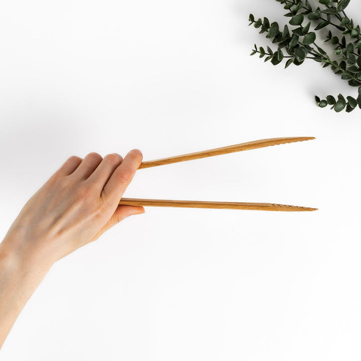Elegant handcrafted wooden tongs with a smooth finish and angled tips, perfect for serving and handling food in a stylish way.