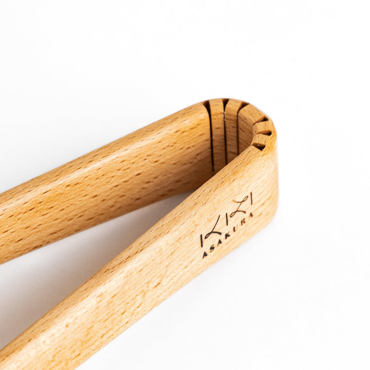 Elegant handcrafted wooden tongs with a smooth finish and angled tips, perfect for serving and handling food in a stylish way.