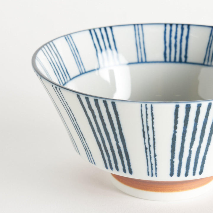 Ceramic ramen bowl with blue striped pattern on white background.