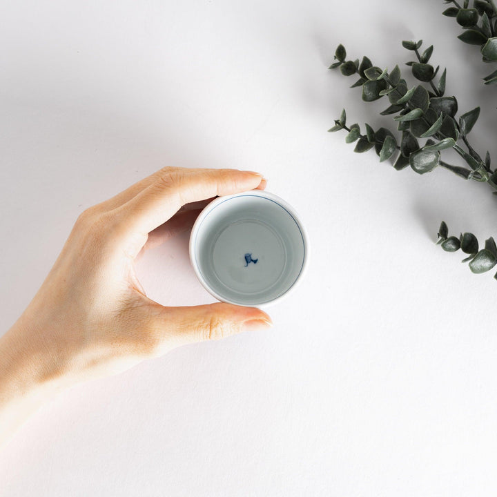 A small white bowl adorned with a delicate blue wave pattern around the edge, perfect for sauces or small sides.