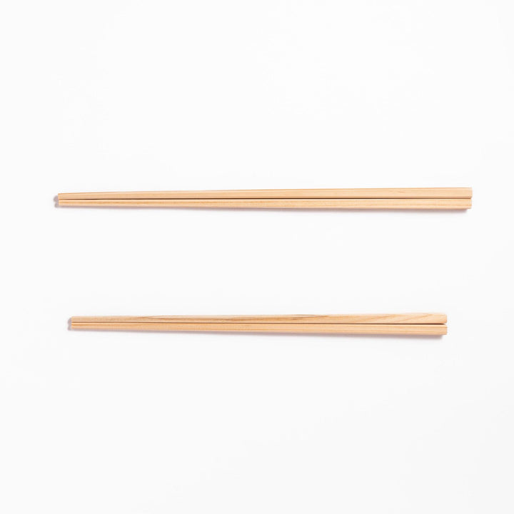 Pair of hinoki wood cooking chopsticks with smooth light wood grain and tapered ends, ideal for Japanese cuisine