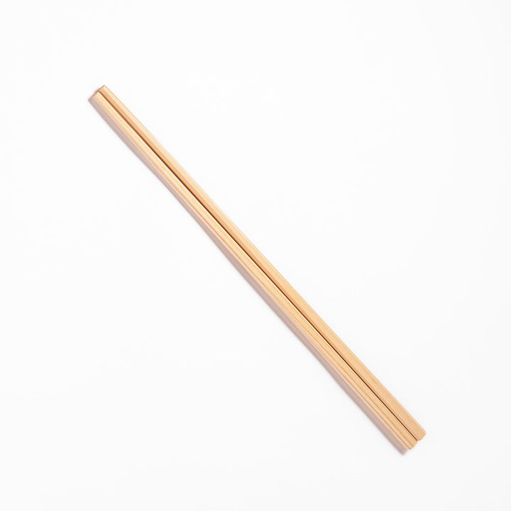 Pair of hinoki wood cooking chopsticks with smooth light wood grain and tapered ends, ideal for Japanese cuisine