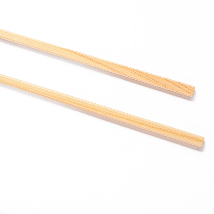 Pair of hinoki wood cooking chopsticks with smooth light wood grain and tapered ends, ideal for Japanese cuisine
