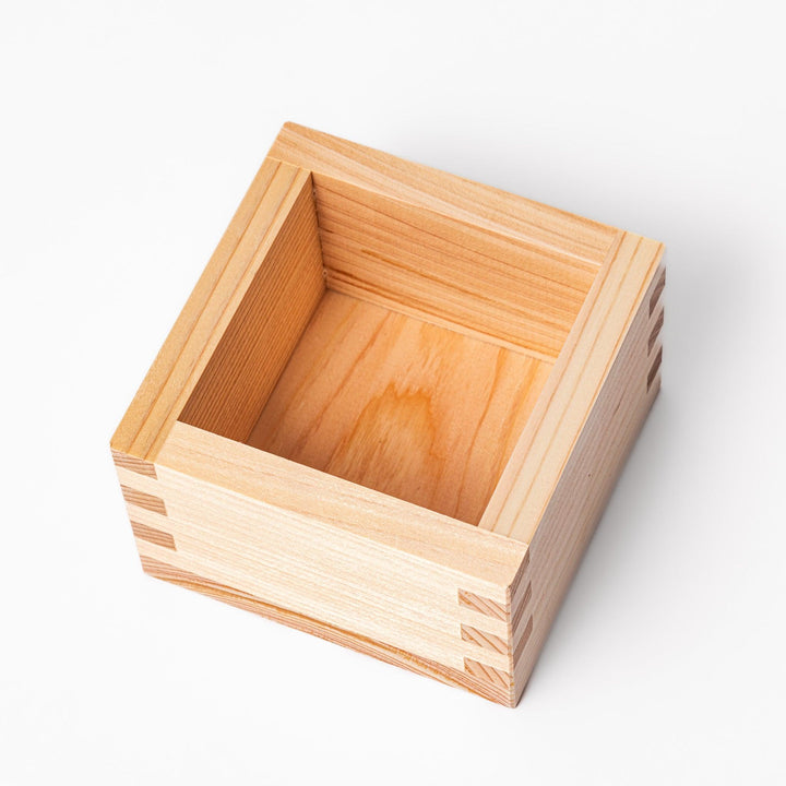 Traditional hinoki wood masu sake cup with visible joinery, offering a natural aroma and authentic way to enjoy Japanese sake or serve condiments.