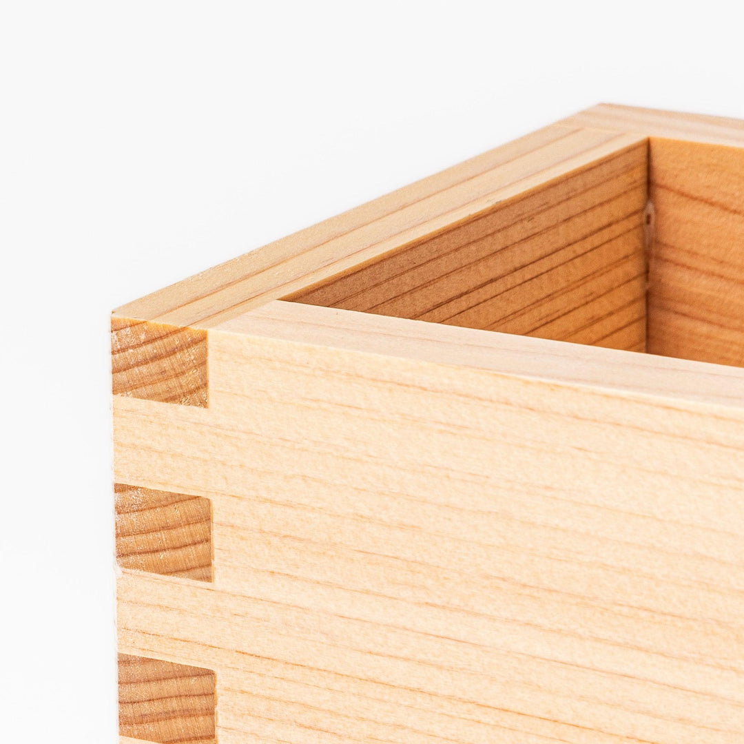Traditional hinoki wood masu sake cup with visible joinery, offering a natural aroma and authentic way to enjoy Japanese sake or serve condiments.